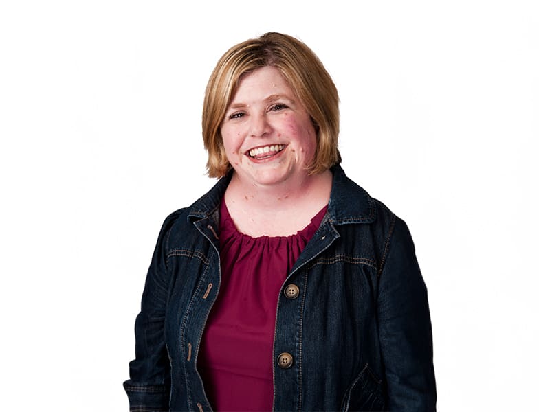 A woman in a red shirt and black jacket