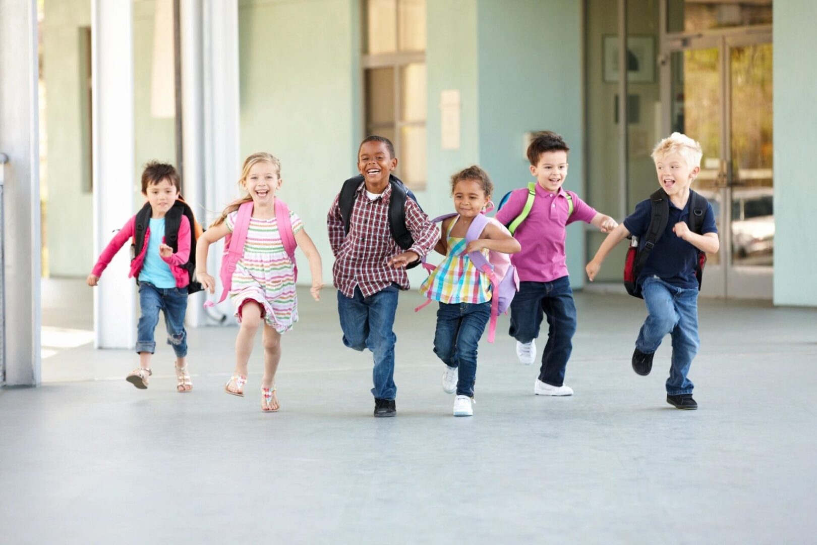 A group of children running in the hallway.